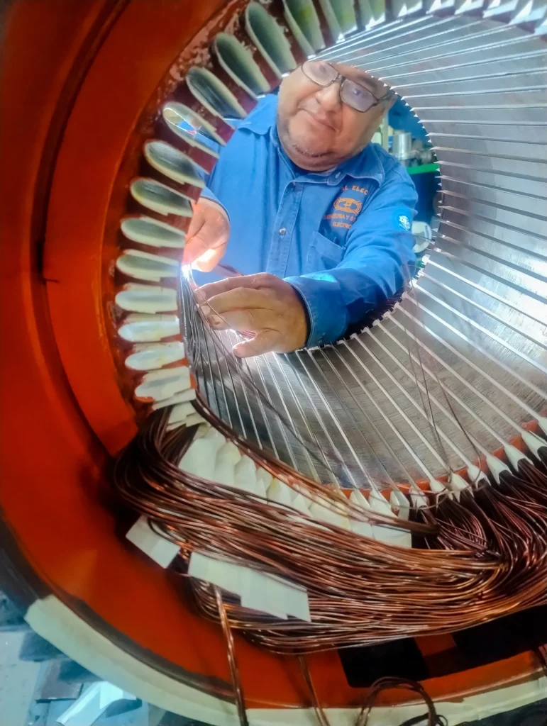 Especialista realiza el proceso artesanal de rebobinado de cobre en un motor para su reparación eléctrica.
